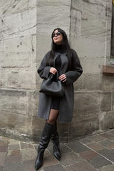 a lady in a black dress and a grey overcoat
